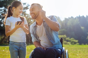 A happy father in a wheelchair with daughter, after receiving assistance from a Social Security Disability Lawyer in East Peoria IL