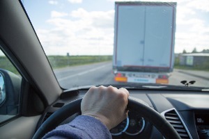 A car driving carefully behind a truck so they don't need a Truck Accident Attorney in Pekin IL