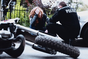 Police talking to a cyclist after an accident, who may now need a Motorcycle Accidents Lawyer in East Peoria IL