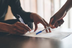 A Motorcycle Accident Lawyer in Pekin IL helping a client file paperwork to receive compensation