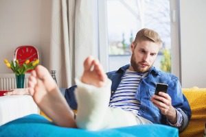 Man with a cast on his leg, calling his Personal Injury Lawyer in Bloomington IL